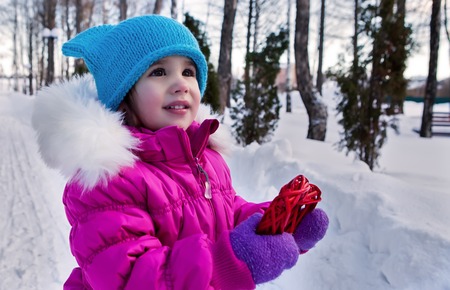 Little girl holding in their hands hearts themes Valentine's day , the day of the winter on the street in the Park.の写真素材