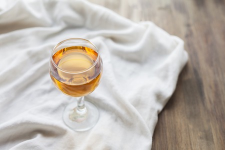 Orange juice in a glass glass on a white cloth on a wooden tableの写真素材