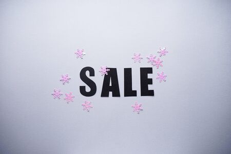 Black friday concept.
Sale on a gray background with confetti, top view.