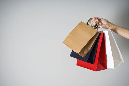 Colored paper, kraft eco packs on a gray background in a female hand, with room for text.の写真素材