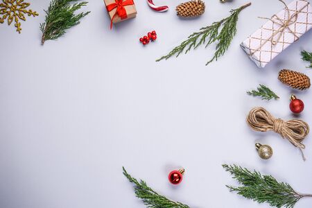 Christmas tree branches with Christmas decorations and gifts on a gray background, with place for text, flat lay.の写真素材