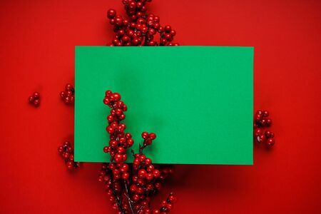 Christmas composition. Christmas red decor on a red background with green place for text, flat lay.の写真素材