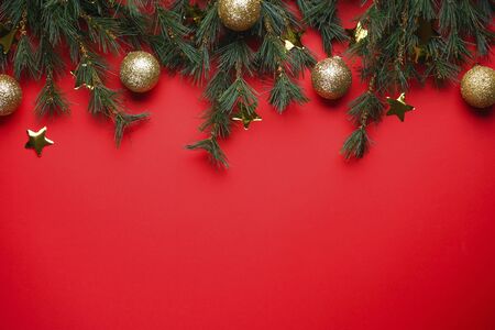 Christmas Tree Branches with toys on a red background with space for textの写真素材