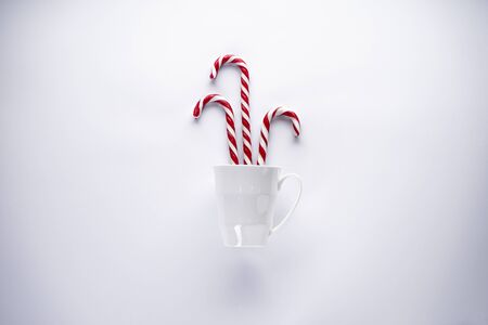 Christmas concept. Christmas candies in a white ceramic cup, on a white background. Flat lay.の写真素材