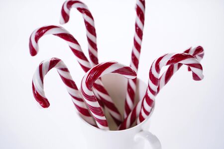 Christmas candies in a white ceramic cup, on a white background. Close up.の写真素材