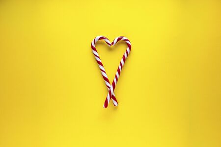 Christmas heart made of sweets on a yellow background. Flat lay, place for text. Christmas and New Year card. Valentine's Day.の写真素材