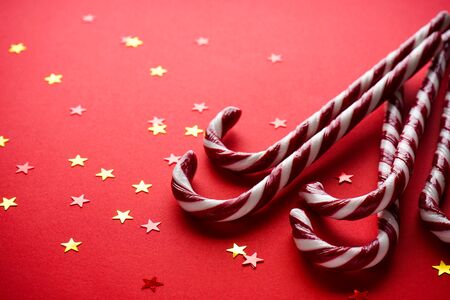 Christmas concept. Christmas candy on a red background with confetti. Traditional Christmas sweets. Close up.の写真素材