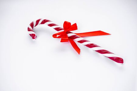 Christmas concept. Christmas candy with a red bow on a white background.の写真素材