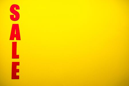 Black friday concept.
Sale in red letters on a yellow background with confetti, place for text top view.の写真素材