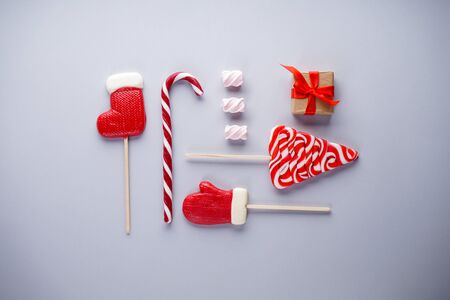 Christmas flat lay composition. Christmas candies with marshmallows and a gift on a gray background.の写真素材