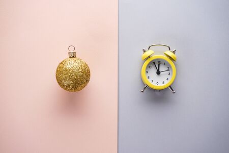 Christmas yellow alarm clock and golden toy, on a colorful background. Flat lay.の写真素材