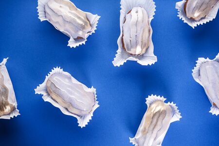 French dessert. Eclairs on a blue background flat lay, close-up.の写真素材