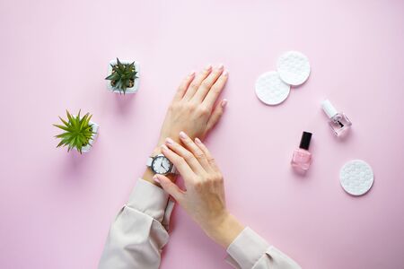 Flat lay beautiful hands of a young girl with a beautiful manicure on a pink background with succulents. French manicure.の写真素材