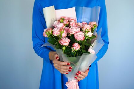 Beautiful bouquet of peony pink roses in female hands with a beautiful manicure.の写真素材