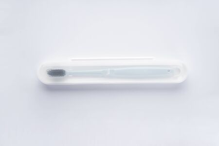 Blue toothbrush with black shield in a white case on a white background. Flat lay. Isolated.の写真素材
