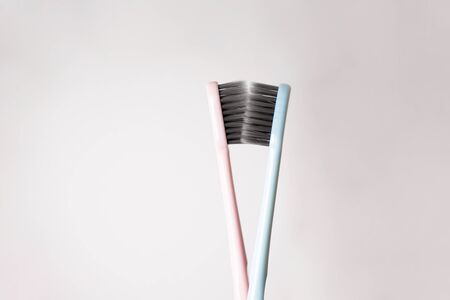 Colored toothbrushes with black bristles on a gray background with close-up, flat lay. Valentines...