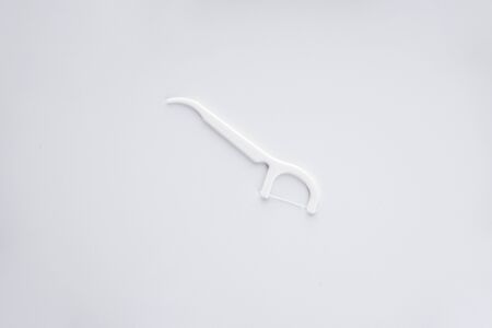 white toothpicks with thread on a white background. Flat lay.