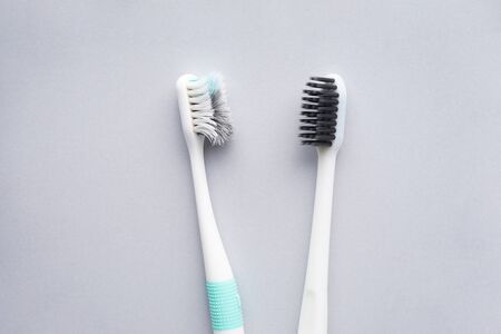 New and old toothbrushes on a gray background, close-up, flat lay. Dental and healthcare concept. の写真素材