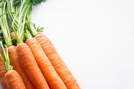 Close-up composition with ripe fresh carrots on white background. Flat lay with space for text.の写真素材