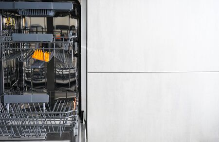 Washing dishes in the dishwasher. An open, empty dishwasher with meta for text.の写真素材