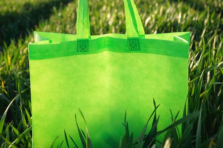 Green bag in the green grass, close-up. Eco bag. Field of wheat.の写真素材
