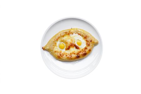 Adjarian Khachapuri with quail eggs and cheese, isolated. On a white ceramic plate. Top view. Georgian cuisine. National cuisine.の写真素材