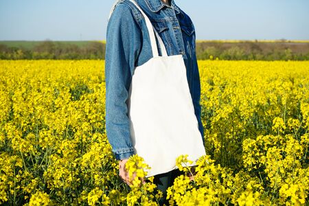 Eco bag. Woman holding an eco bag outdoors. Mockup for design.の写真素材