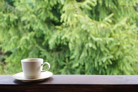 A cup of tea on the railing of the terrace. with place for text. Closeup.の写真素材
