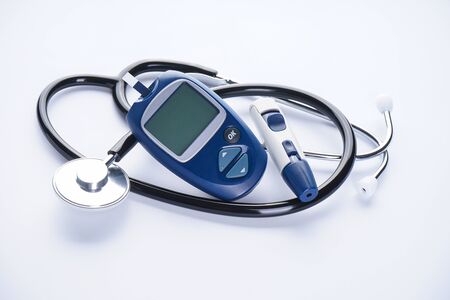 Digital glucometer and lancet pen, stethoscope on white background, concept of health.の写真素材