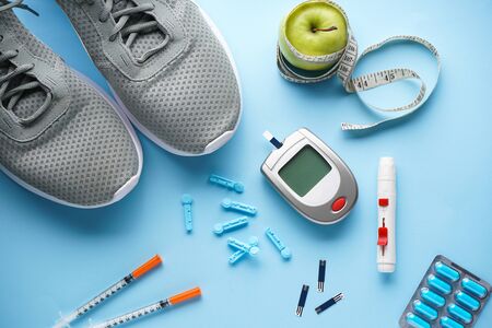 Sports diabetic. Digital glucometer. Concept of a healthy diabetic on blue background. Flat lay.