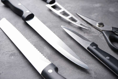 A set of knives. Various kitchen utensils on a gray table background, flat lay, with place for text.