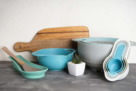 Kitchen utensils and succulent on a gray background.