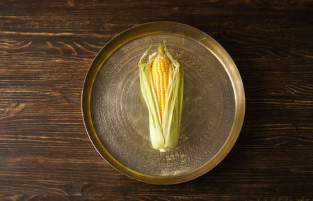 Ripe corn in a tray on a wooden background, flat lay.の写真素材