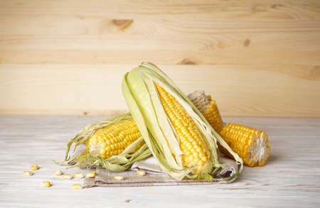 Ripe ears of corns on a wooden background.