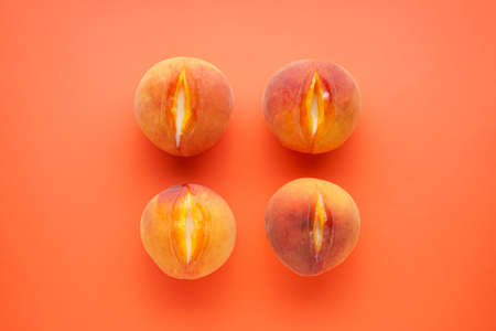 Fresh peaches on an orange background, top view. Sex conceptの写真素材