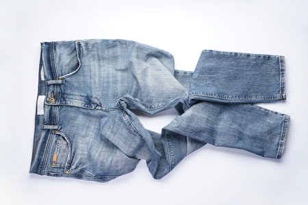 Folded blue mens denim jeans trousers isolated on white background.の写真素材