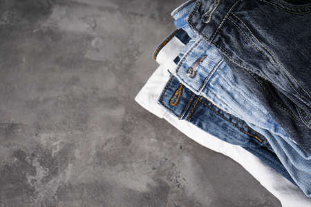 Folded jeans on gray background with place for text. Flat lay.の写真素材