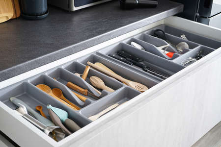 Open drawer with cutlery in kitchenの写真素材