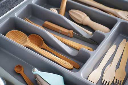 Set of clean kitchen utensils in drawer.