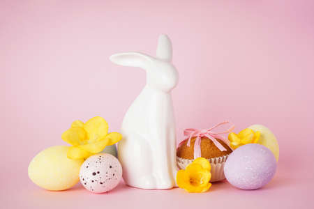 Happy Easter concept. Easter cake, Easter bunny and eggs with flowers on a pink background.の写真素材
