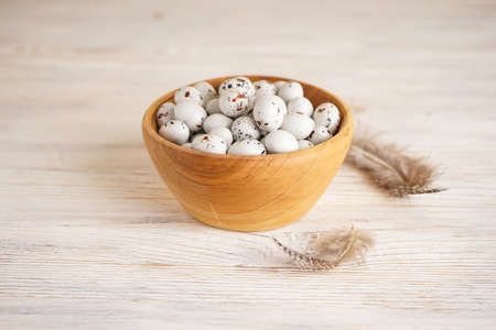 Quail easter eggs in wooden bowl on wooden background.の写真素材