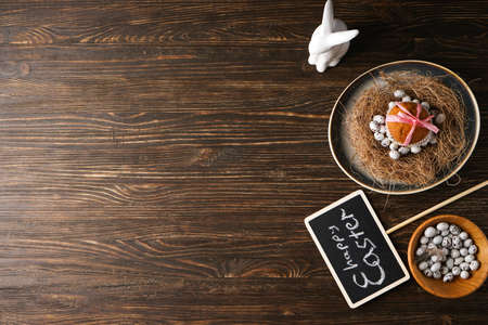 Table setting with easter decorations on wooden table. Top view, space for text.
