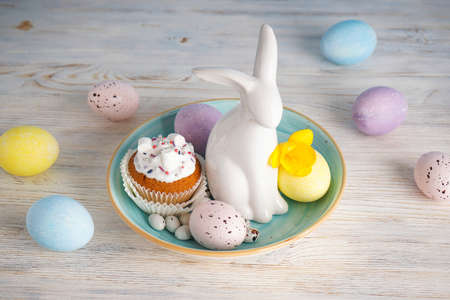 Happy Easter concept. Easter cake, Easter bunny and eggs with flower on a wooden background.