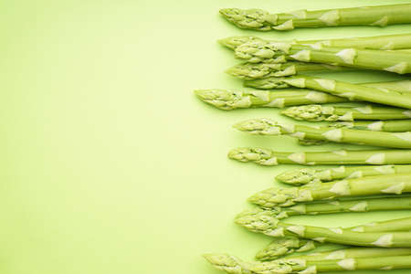Fresh green asparagus on a green background, place for text.の写真素材