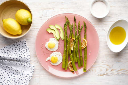 Stir-fried eggs with green asparagus in a plate on a wooden background. Top view.の写真素材