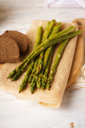 Baked asparagus and black bread on a wooden background.の写真素材