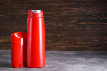 Bottle of shampoo and deodorant on a wooden background. Space for text.