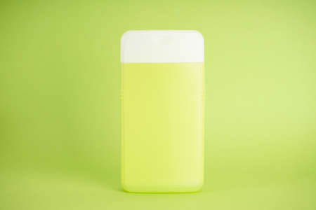 Light green shampoo bottle on light green background, close-up.の写真素材