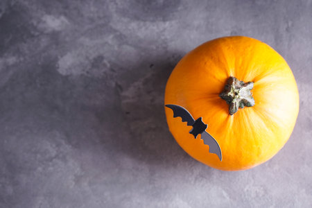 Halloween pumpkin and bat on gray background, space for text. Top view.の写真素材