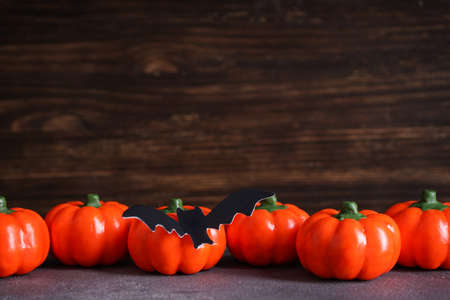 Halloween pumpkins and bats on a wooden table. Space for text.の写真素材